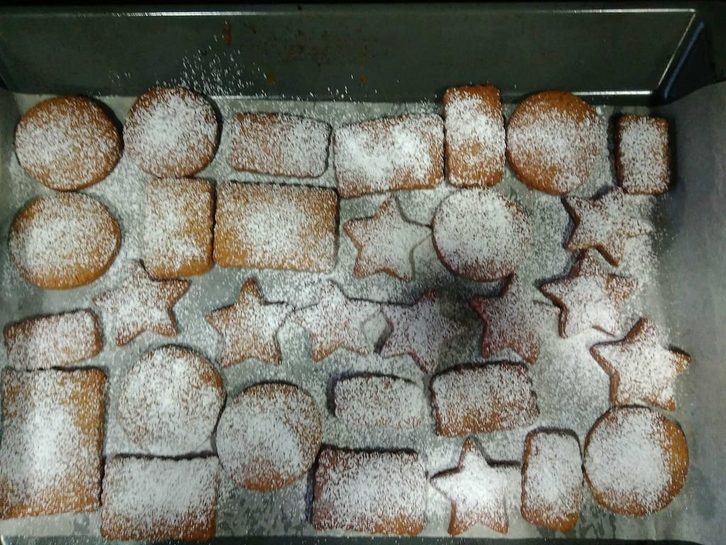 honey cinnamon gingerbread cookies of various shapes with icing sugar on top