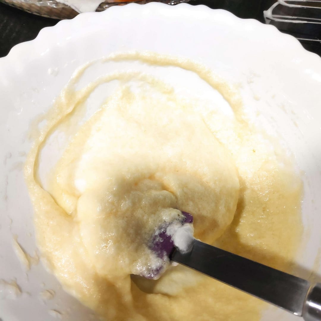 En un bol el proceso de mezclar las yemas y claras con una espáatula