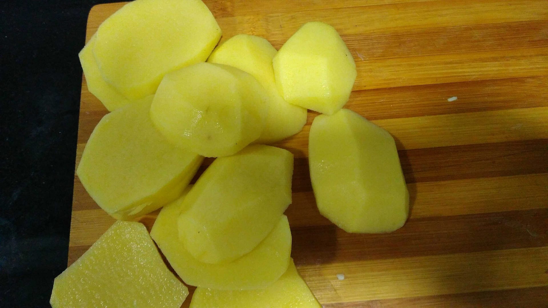 patatas crudas cortadas en rodajas sobre tabla de madera
