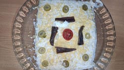 pastel de patatas y atún decorado con anchoas, olivas
