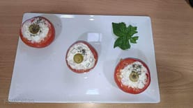 tomates rellenos frios, tres en una fuente blanca rectangular