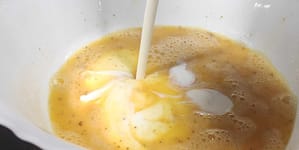 en un bol añadiendo crema de leche a los huevos batidos