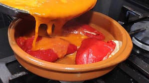 vertiendo la salsa en la cazuela sobre los pimientos