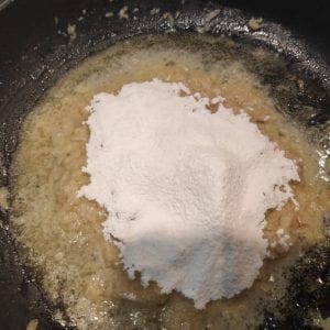 harina en la sartén sobre la cebolla cocinada