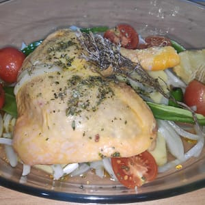 Pollo con verduras y hierbas en una fuente de horno