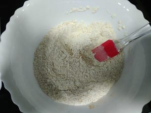 en un bol blanco con una espátula mezclado la harina, el azúcar, la sal, el bicarbonato