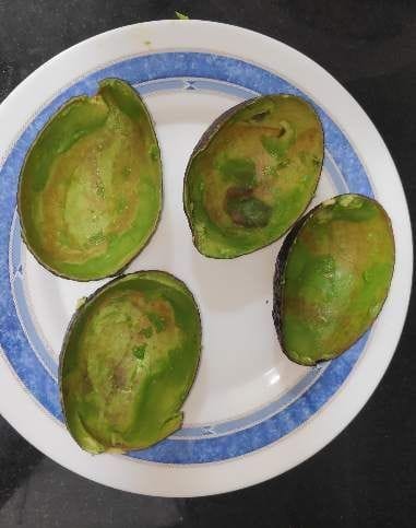 a plate with four empty avocado halves