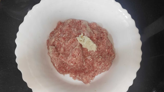 Meat in a bowl with breadcrumbs with drained milk