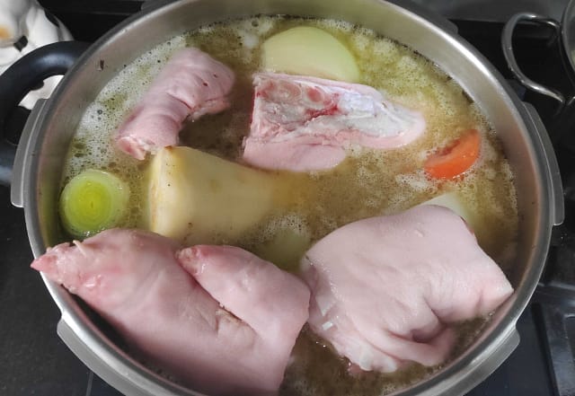 Meat and pig feet cooking in a pot
