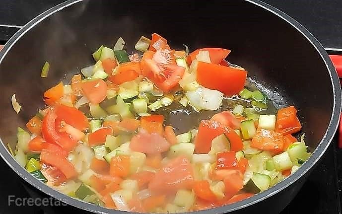 tomate añadido a las verduras en la cazuela