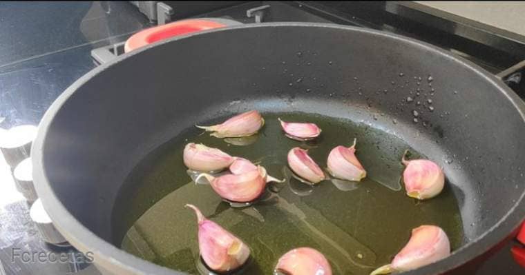 garlic in a casserole with oil, garlic with skin one garlic head