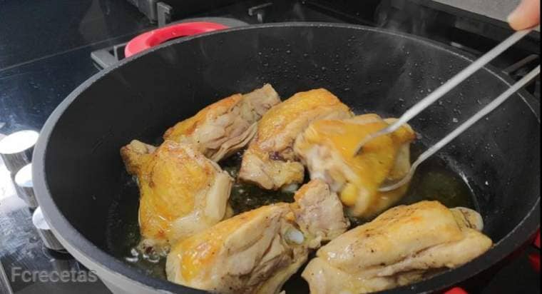 chicken cut into pieces in a pan with oil, we turn it over