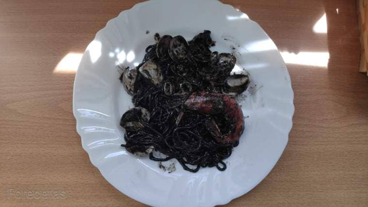 un plato de espaguettis negro con calamar