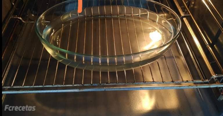 un recipiente con agua en la rejilla del horno