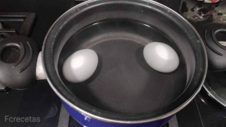 dos huevos cociéndose en agua hirviendo
