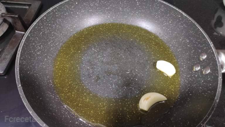 in a frying pan oil and two peeled garlic
