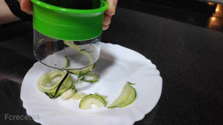 with a manual spiralizer making courgette spaghetti