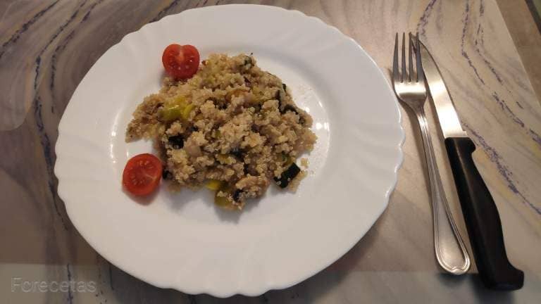 un plato con quinoa con verduras y unos cubiertos