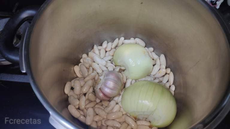 En una olla fabas, cebolla y una cabeza de ajo