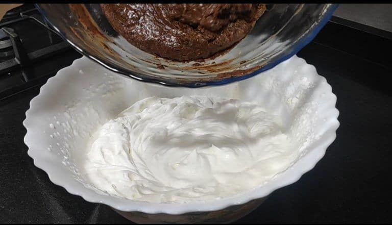 adding the chocolate mixture to the whipped cream