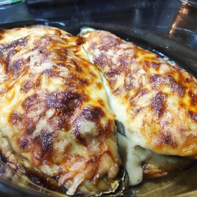 dos berenjenas rellenas con queso gratinado encima