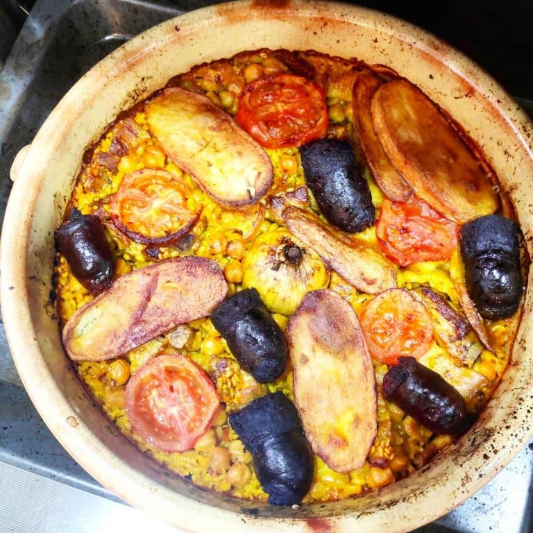 una cazuela de barro con arroz al horno valenciano, con patata, tomate, morcilla, chorizo