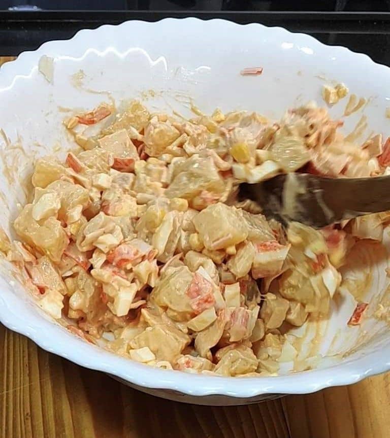 ingredientes de la ensalada de cangrejo mezclados con salsa rosa